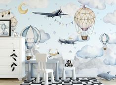 a child's room decorated in blue and white with hot air balloons