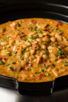 a black pan filled with beans and vegetables