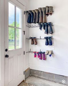 there are many pairs of boots hanging on the wall next to the door and window