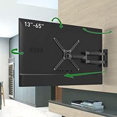 a large tv mounted to the side of a wall with two green arrows pointing towards it