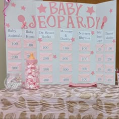 a baby shower game is set up on a table with pink and gold decorations,