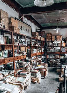 a room filled with lots of books and boxes on the shelves next to each other