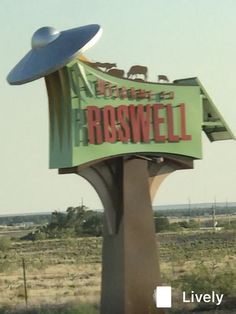 the sign for roswell is in front of an open field