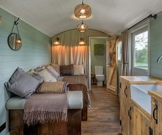 the interior of a tiny home with wood flooring and walls, including a kitchen