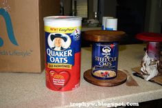 two jars of oats are sitting on the counter next to a cardboard box and scissors