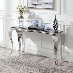 an elegant console table with two vases on it