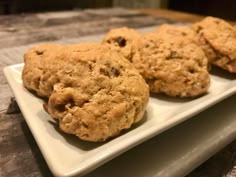 three cookies on a white plate sitting on a table