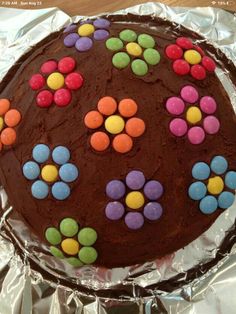 a chocolate cake decorated with colorful candies on aluminum foil