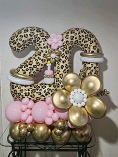 the number twenty one decorated with balloons in leopard print and pink, gold and white colors