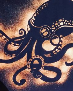 an octopus is drawn on the ground in black and gold colors with white circles around it