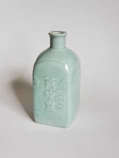 a green glass bottle with chinese writing on it