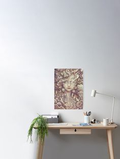 a desk with a plant on it next to a white wall and a wooden floor