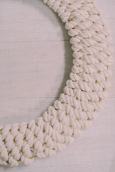 a close up of a white necklace on a wooden surface