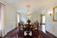 a formal dining room with chandelier, table and chairs