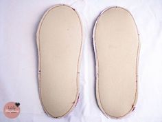 a pair of slippers sitting on top of a white sheet