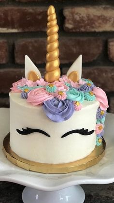 there is a cake decorated with flowers and a unicorn's horn