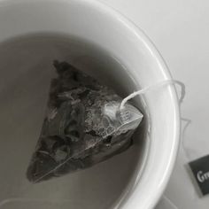 a piece of cake sitting in a white bowl on top of a table next to a tag