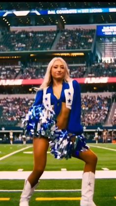 a cheerleader is posing on the field at a football game