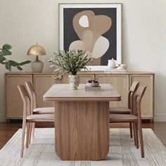 a dining room table with chairs and a plant in the middle on top of it