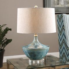 a blue lamp sitting on top of a glass table