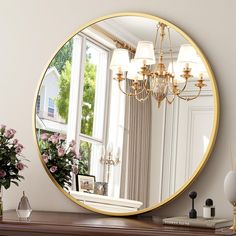 a mirror sitting on top of a table next to a vase with flowers in it