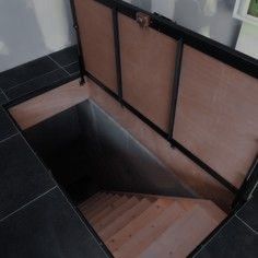 an open suitcase sitting on top of a black tile floor next to a window and door