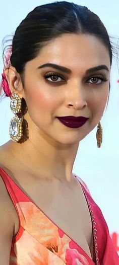 a woman with dark lipstick and large earrings