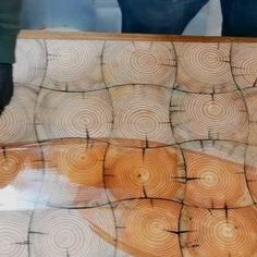 the reflection of a person standing in front of a window with wood slices on it