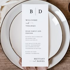 a place setting with white plates and silverware on it, including a menu card