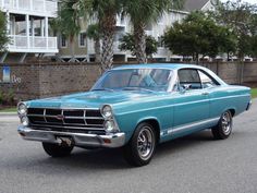 an old blue car parked on the street