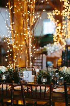 the table is set up with place settings and flowers on it for an elegant dinner