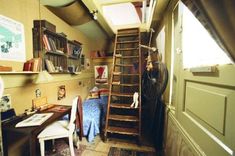 a ladder in the corner of a room next to a desk