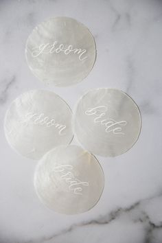 three personalized glass coasters on a marble surface