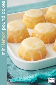 a white tray filled with glazed donuts on top of a blue and white cloth