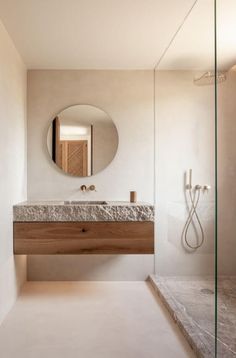 a bathroom with a sink, mirror and shower stall in it's center area