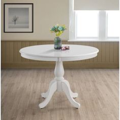 a white table with flowers in a vase on it