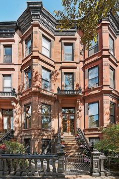 an apartment building with many windows and balconies on the second floor, next to a wrought iron fence