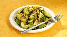 a white bowl filled with sliced avocado on top of a yellow tablecloth