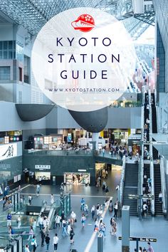 the inside of a train station with people walking around and on escalators in front of it