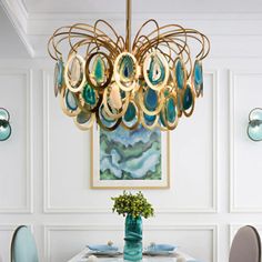 a dining room table with chairs and a chandelier hanging from it's ceiling