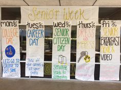 several signs on the front door of a building that say senior week and career day