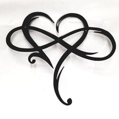 a black metal heart shaped object on a white background with the word love written in it