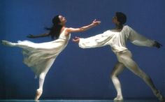 two people in white dresses are dancing together