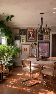 a dining room table with chairs and pictures on the wall in front of it's windows