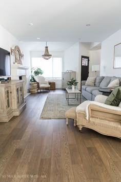 a living room filled with furniture and a flat screen tv on top of a wooden floor