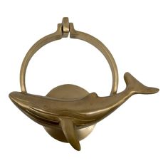 a brass whale bottle opener on a white background