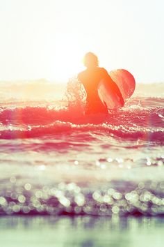 a person riding a surfboard on top of a wave in the ocean at sunset