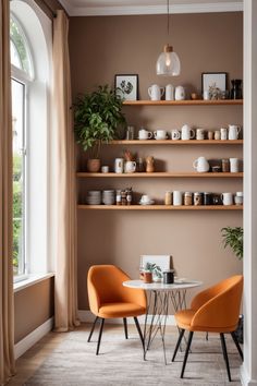 Cozy nook with orange chairs, a small table, and shelves displaying kitchenware against a brown wall. Coffee Corner With Chairs, Coffee Sitting Area In Kitchen, Modern Coffee Nook, Coffee Sitting Area, Sitting Area In Kitchen