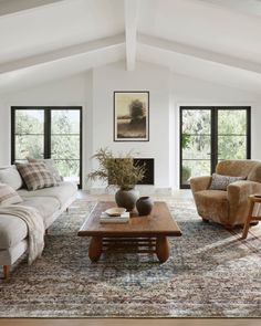 a living room with two couches and a coffee table in front of the fireplace