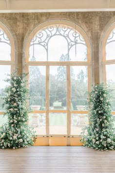 an open window with flowers and greenery in front of it